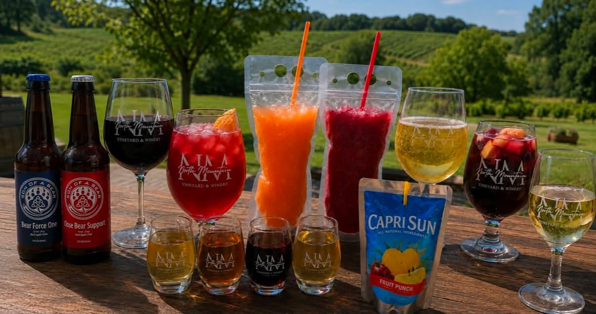 Think we only serve wine? Think again. At North Mountain Vineyard & Winery, we’ve got a little bit of everything: 🍷 Wine - duh!! 🍎 2 ciders on tap: • Off the Press (Apple Cider) Old Hill • Rhubeary Pursuit (Strawberry Rhubarb) Son Of a Bear 🍏 2 bottled ciders from Son of a Bear: • Bear Force One - Traditional Semi-Dry Apple Cider • Close Bear Support - Peach Cider Aged in Rye Barrels 🍯 Mead - because sometimes you need to drink like a Viking (4 flavors to choose from!) 🍹 Wine cocktails 🍓 In-house made sangria (Red & White!) 🍧 Wine slushies (because adulting is hard and slushies make it better) 🍹 Mocktails for our non-drinking friends 🥤 Non-alcoholic beverages 🧃 Capri Suns… because your inner child deserves a treat too. Basically, if your group can’t decide what they want to drink, send them here. We’ve got something for everyone, from the wine snob to the person who still gets excited about a Capri Sun. Come sip, relax, and enjoy the vineyard views with us! 🍇☀️ #NorthMountainVineyard #NorthMountainWinery #VirginiaWine #VirginiaWineries #VisitVirginia #VirginiaIsForLovers #ShenandoahValley #ShenandoahValleyVA #DrinkLocal #SupportLocal #WineryLife #WineLover #WineTime #WineNot #SipSipHooray #CheersYall #WeekendVibes #SummerSips #WineSlushies #SangriaSeason #CiderLovers #MeadLovers